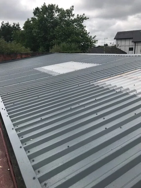 Industrial roof mid-replacement, new sheeting fitted alongside the original roof and rooflight