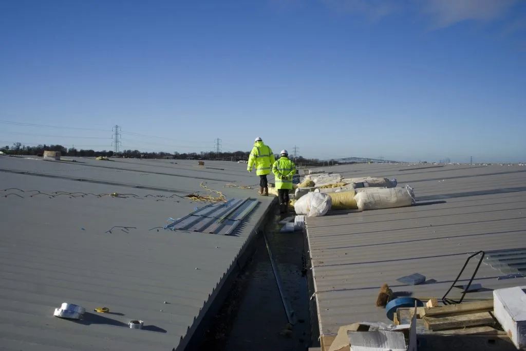 Roofing team working on a large industrial warehouse roof